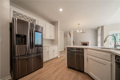 Kitchen featuring appliances with stainless steel finishes, a sink, white cabinetry, light wood-style flooring, and recessed lighting