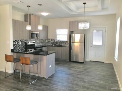 Kitchen featuring appliances with stainless steel finishes, dark countertops, modern cabinets, and a peninsula