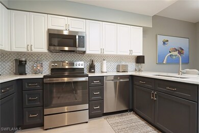 Kitchen with stainless steel appliances, a sink, white cabinets, and backsplash