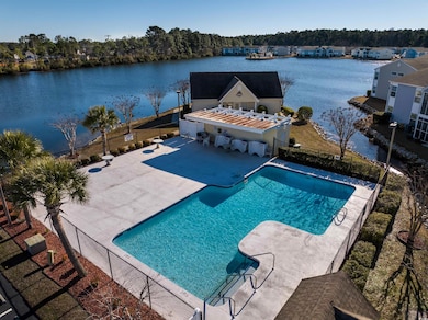 Community pool featuring a patio, a water view, an