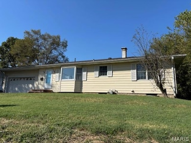 Ranch-style house with a garage, a front lawn, and a chimney