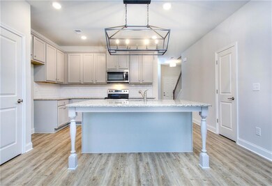 Kitchen with stainless steel appliances, light har