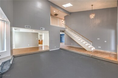 Living room with concrete flooring, stairs, a high
