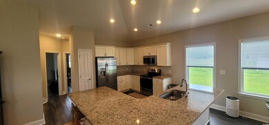 Kitchen featuring lofted ceiling, sink, white cabi