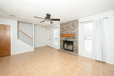 Unfurnished living room with a ceiling fan, stairw
