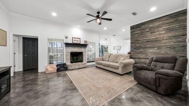 Living room featuring ceiling fan and ornamental molding