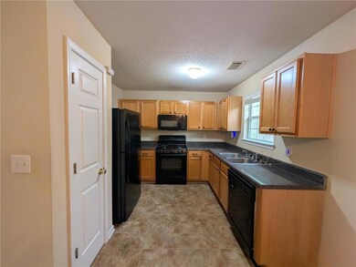 Kitchen with dark countertops, visible vents, a si