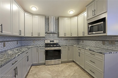 Kitchen featuring tasteful backsplash, wall chimne