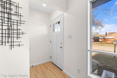 Entrance foyer featuring light wood-style floors and baseboards
