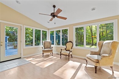 Sunroom / solarium featuring vaulted ceiling and c