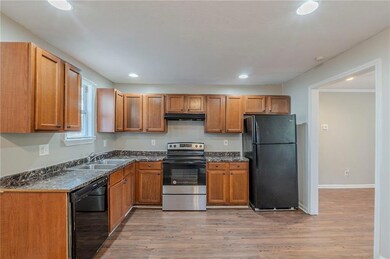 Kitchen with baseboards, under cabinet range hood,