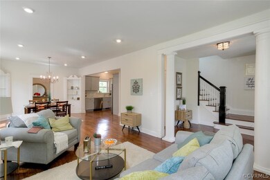 Open and Bright Living Room with Refinished Hardwood Floors, Brick Fireplace, Recessed Lighting and open to Dining Room