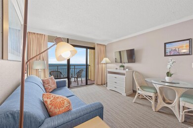 Living room featuring light carpet, a textured ceiling, and ornamental molding
