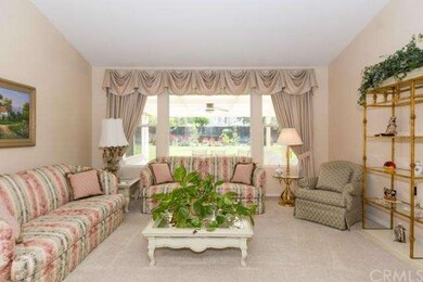 Formal living room with large windows looking out to beautifully manicured yard.