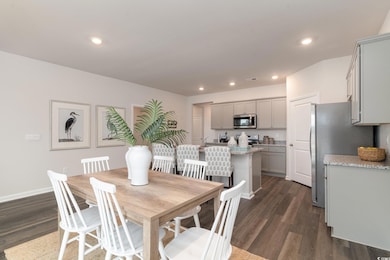 Dining area featuring dark wood-style floors, recessed lighting, and baseboards