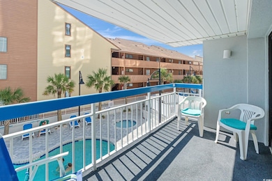 Balcony with a community hot tub and view of pool area