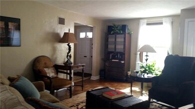 Another view of the living room with view of front entry. Coat closet is to right of window.