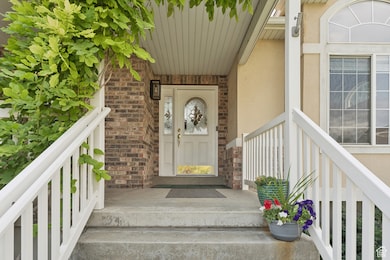 Entrance to property featuring stucco siding, covered porch, and brick siding