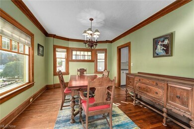Dining space with an inviting chandelier, crown molding, and dark hardwood / wood-style floors