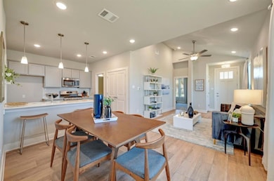 Dining space featuring lofted ceiling, light wood