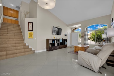 Living room featuring high vaulted ceiling, stairs