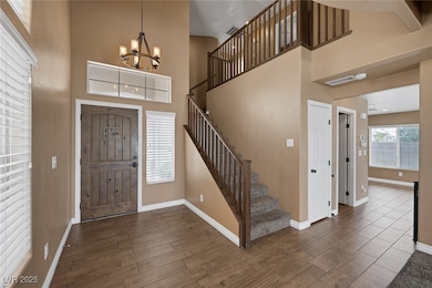 Entryway featuring a chandelier, baseboards, dark