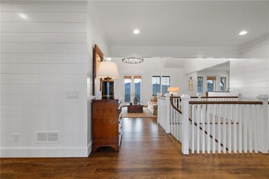 Hallway with visible vents, dark wood finished flo