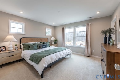 Bedroom featuring light carpet, multiple windows, and recessed lighting