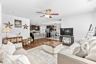 Living room featuring ceiling fan and dark hardwoo