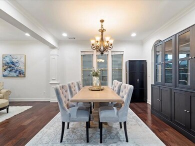 Dining room featuring a chandelier, dark wood-type flooring, recessed lighting, and ornamental molding