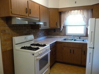 Kitchen. Gas range with newer refrigerator.  Windo