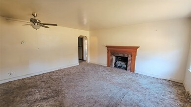 Unfurnished living room featuring ceiling fan, a f