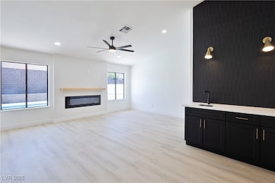 Unfurnished living room with visible vents, a sink