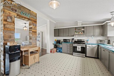 Kitchen featuring stainless steel appliances, vaulted ceiling, gray cabinetry, open shelves, and light flooring