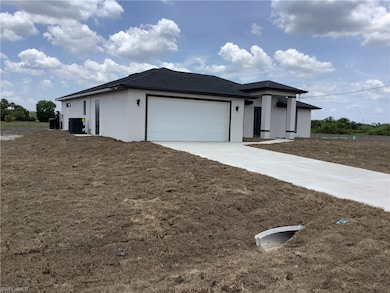 View of front of home with central AC, a garage, stucco siding, and driveway