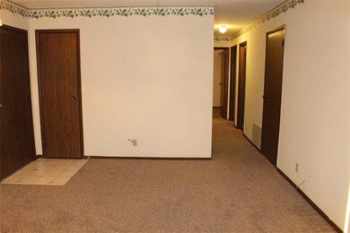 Formal living room and hallway leading to bedrooms
