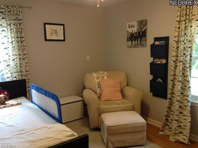This first floor bedroom has wood floors and a lov