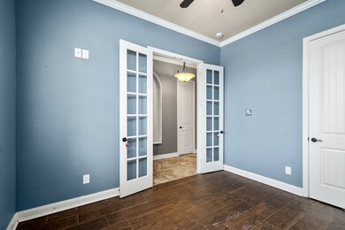 Stately office or perfect bedroom? You decide. With wood look tile and crown molding this room can  be just about what ever you want it to be.