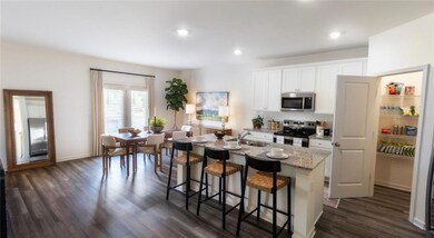 Kitchen featuring an island with sink, dark wood-t