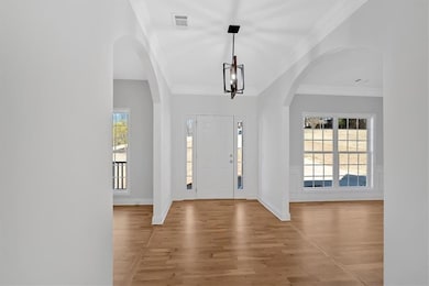 Foyer entrance featuring arched walkways, light wo
