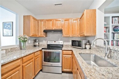 Updated kitchen with newer stainless steel range, backsplash, granite tops and tile floor!