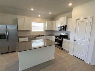 Kitchen featuring backsplash, appliances with sta