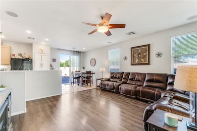 Living area featuring a ceiling fan, wood finished floors, plenty of natural light, and recessed lighting
