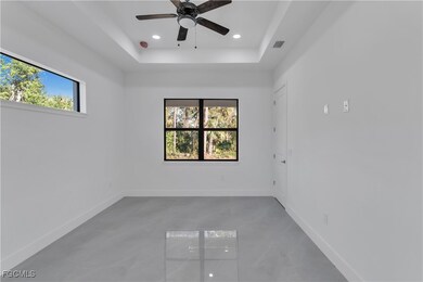 Empty room with recessed lighting, a tray ceiling, finished concrete floors, and a ceiling fan
