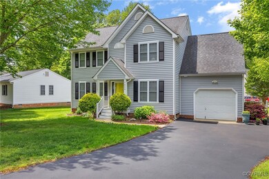 View of front of home featuring a garage, roof wit