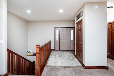 Spacious entry with recessed lights, coat/storage closet, nook for bench/seat, opens to living.