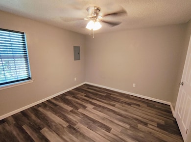 Empty room with dark wood-style flooring, ceiling 