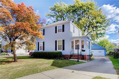 View of front of home featuring an outdoor structure, a front yard, and a garage