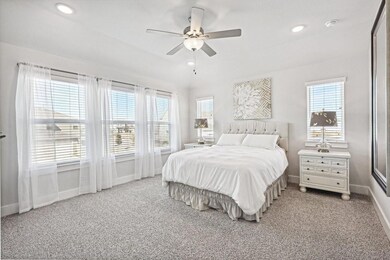 Bedroom with ceiling fan, light colored carpet, an