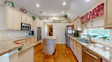 Looking through the kitchen, notice the double ovens, island, granite counters and the refrigerator is included!